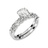 Round brilliant center stone with decorative multi-shape pavé shanks and matching wedding band.