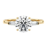 Luxury round brilliant moissanite engagement ring in yellow gold with architectural tapered baguette side stones ApolloGem South Africa.