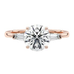 Elegant bridal stack featuring a round three-stone moissanite ring paired with a slim gold wedding band for a luxury look.