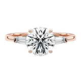 Elegant bridal stack featuring a round three-stone moissanite ring paired with a slim gold wedding band for a luxury look.