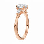 Top-down view of a symmetrical round brilliant ring with tapered baguettes on a polished 9k rose gold shank.