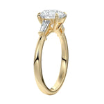 Side view of a high-set round moissanite ring showing the secure four-prong setting and structural baguette accents.