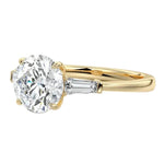 Detailed close-up of a GRI certified D-color VVS1 round brilliant moissanite with crisp tapered baguette side stones.