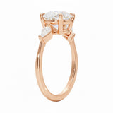Top-down view of a symmetrical round brilliant ring with kite accents on a polished rose gold comfort-fit shank.