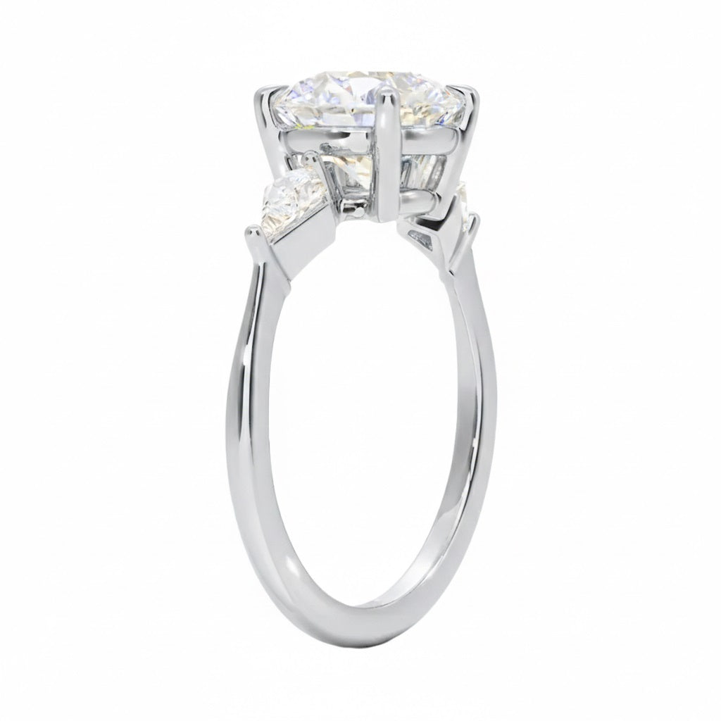 Detailed side view of a round moissanite ring showing the secure four-prong setting and geometric kite-shaped side stones.