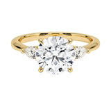 Luxury round brilliant moissanite engagement ring in yellow gold with two elegant pear cut side stone accents ApolloGem South Africa.