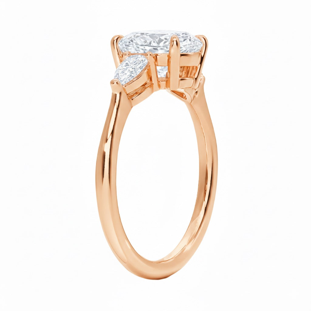 Rose gold ring with a central diamond and two smaller diamonds on a white background