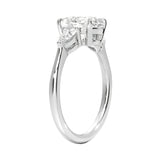 Top-down view of a symmetrical round moissanite ring with two pear side stones on a polished yellow gold comfort-fit shank.
