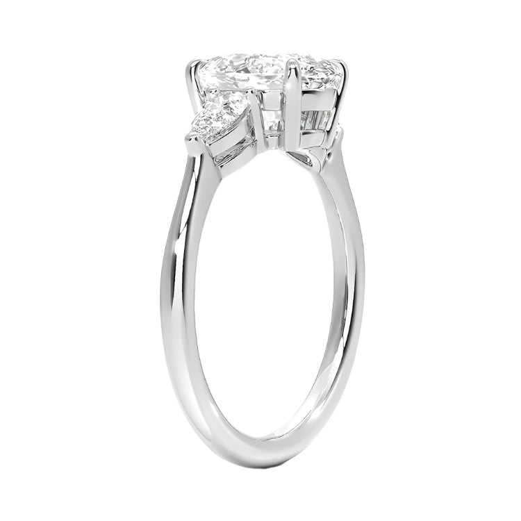 Top-down view of a symmetrical round moissanite ring with two pear side stones on a polished yellow gold comfort-fit shank.