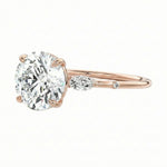 Gold ring with a large diamond and smaller diamond on a white background