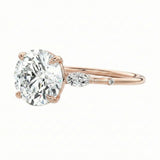 Gold ring with a large diamond and smaller diamond on a white background
