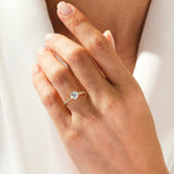 Dainty yellow gold engagement ring with a round brilliant moissanite and pavé band shown on a woman's hand ApolloGem Cape Town.