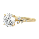 Detailed side view of a six-prong round moissanite ring showing the professional basket setting and pavé shoulder accents.