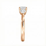 Symmetrical top-down view of a graduated three-stone round moissanite ring in polished solid gold.