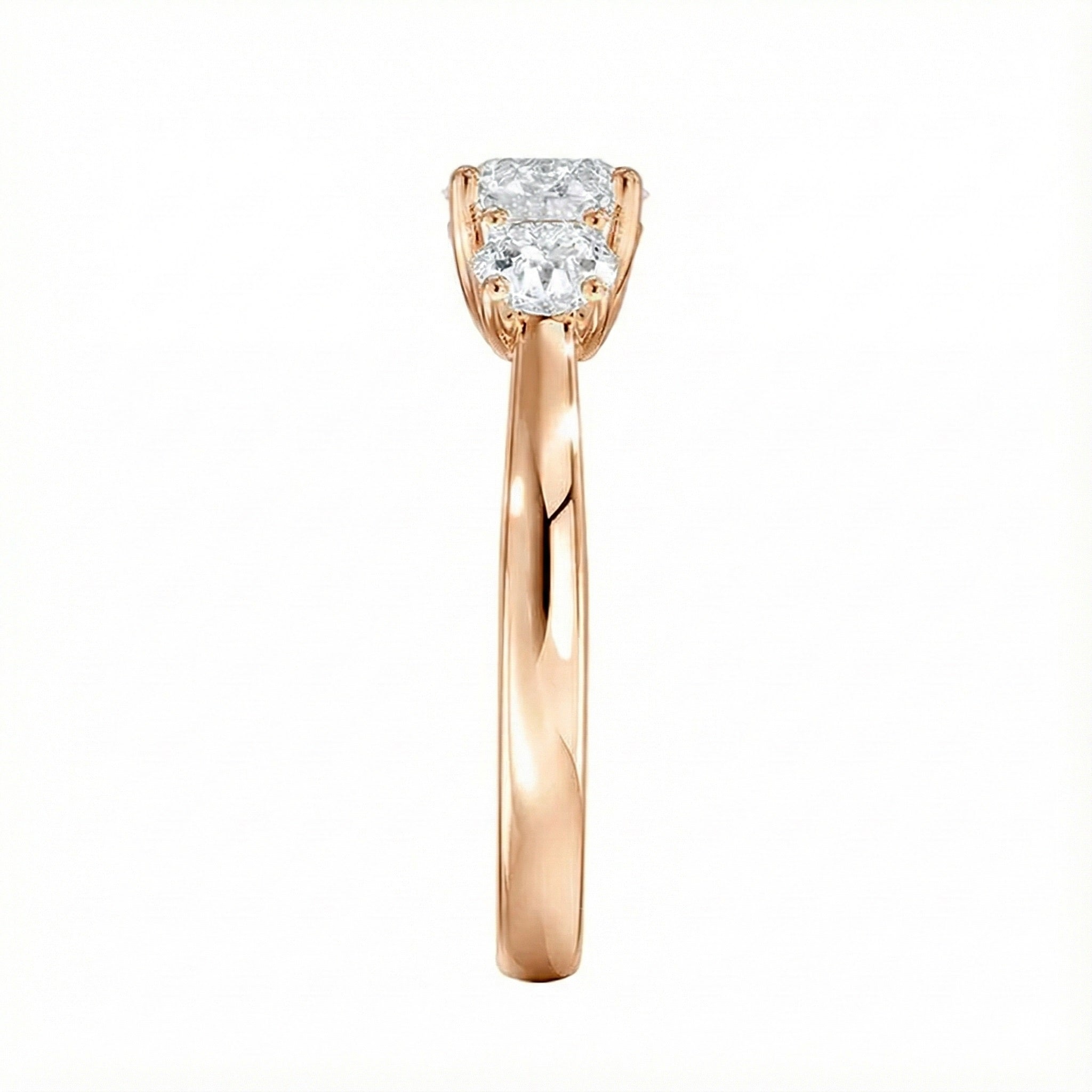 Symmetrical top-down view of a graduated three-stone round moissanite ring in polished solid gold.