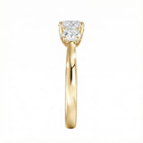 Symmetrical top-down view of a graduated three-stone round moissanite ring in polished solid gold.