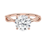 Round brilliant moissanite engagement ring with a twisted infinity-style rose gold band ApolloGem.