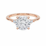 Round brilliant moissanite engagement ring with pear cut side stones rose gold