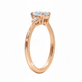 Rose gold ring with three diamonds on a white background