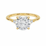 Round brilliant moissanite engagement ring with pear cut side stones yellow gold